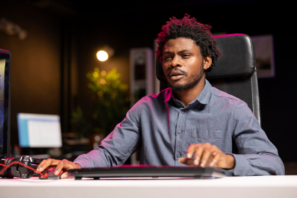 Aspiring Nigerian tech professional studying frontend development on a laptop at home in Lagos